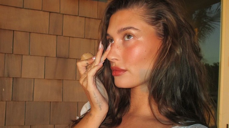 Hailey Bieber applying lip blush