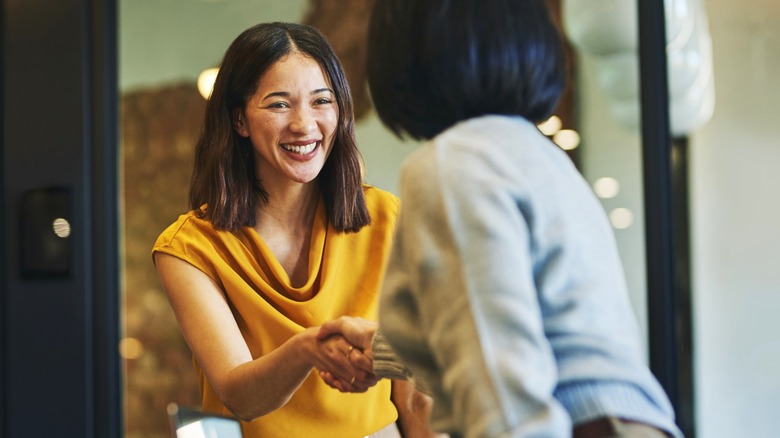 Smiling women shaking hands