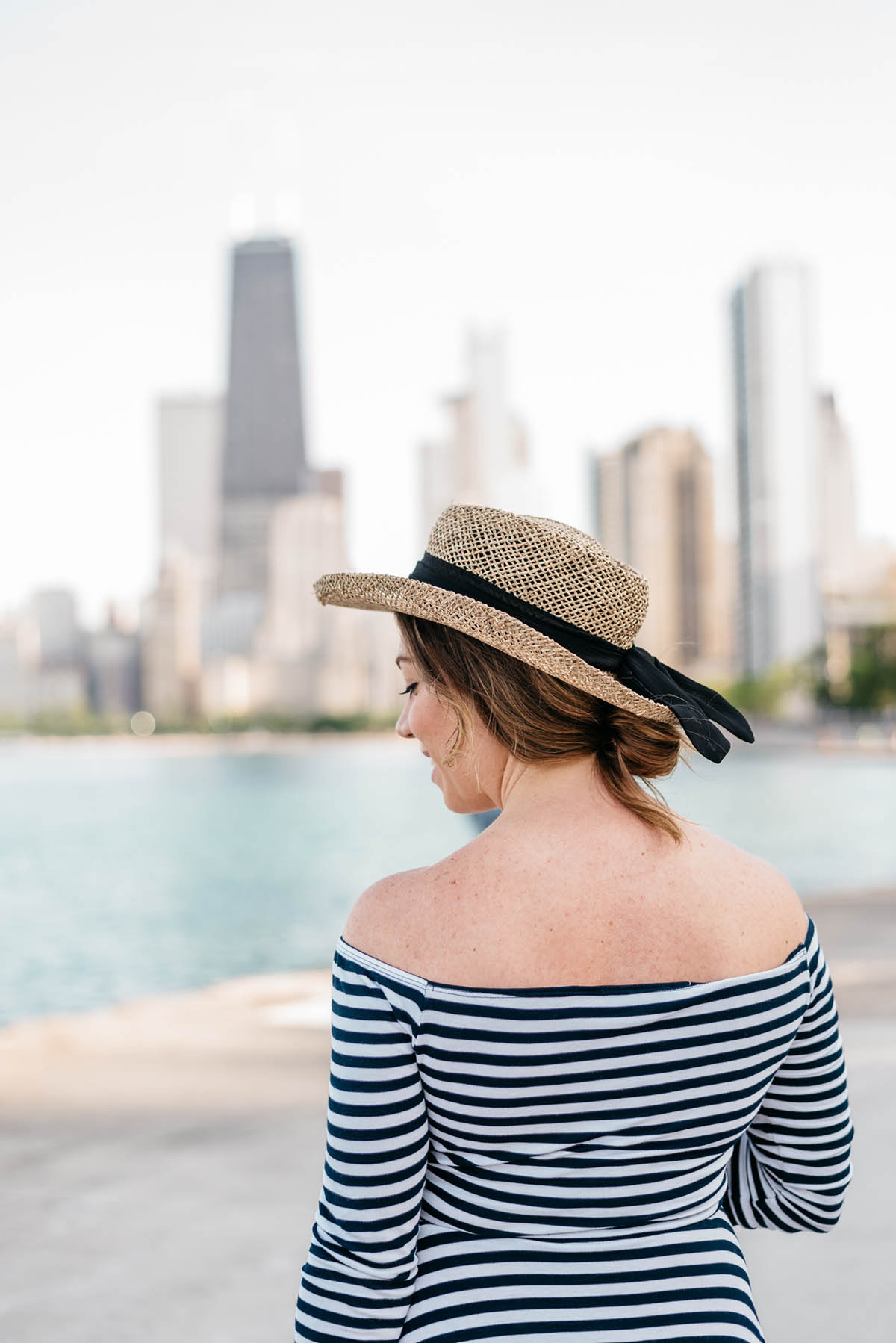 straw fedora hat and striped dress in front of the chicago skyline